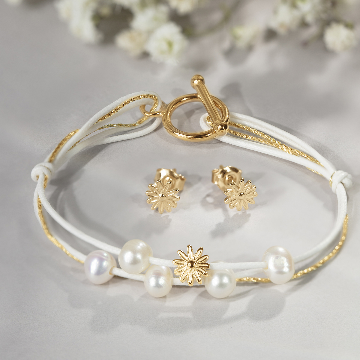 Bracelet Flowers Etincelle doré à l’or fin et perles blanches sur un double fin cordon blanc